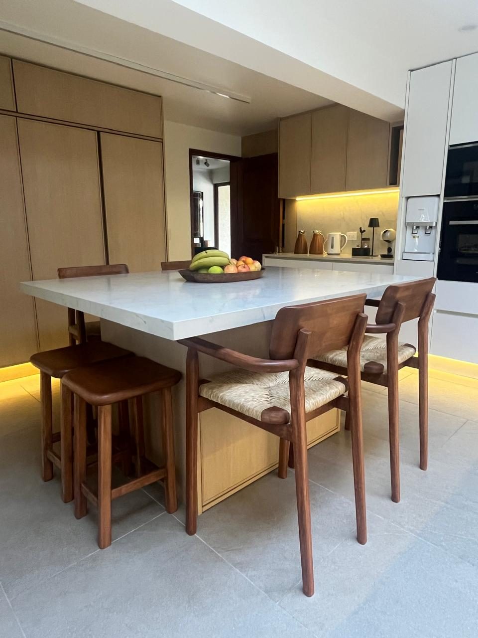 Cocina y comedor con cubierta de mármol y sillas de madera — remodelación