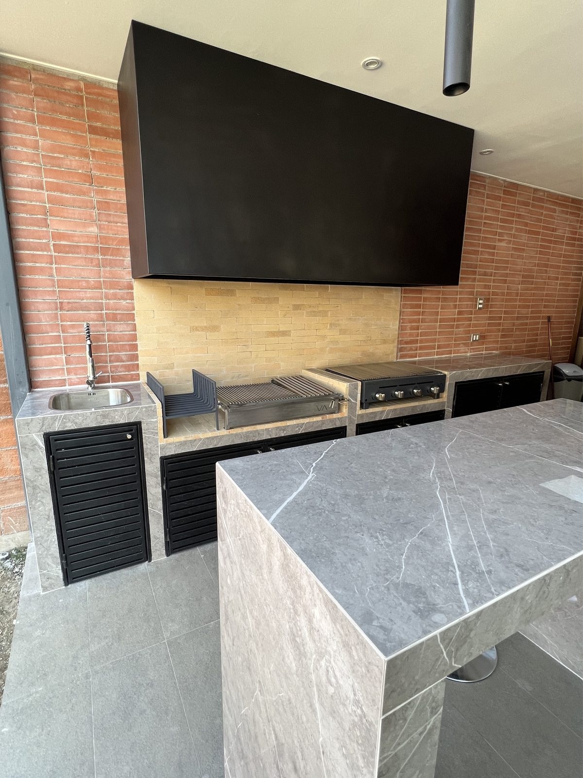 Parrilla a obra con muro de ladrillo y cubierta de mármol — quincho premium